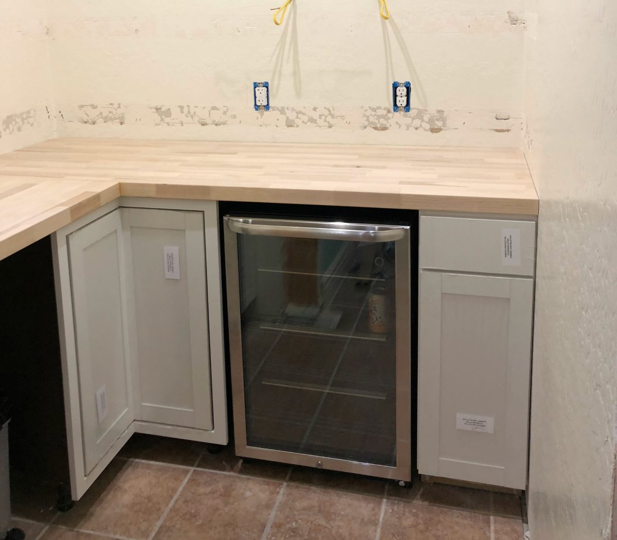 the pantry in progress with added cabinets and a mini fridge