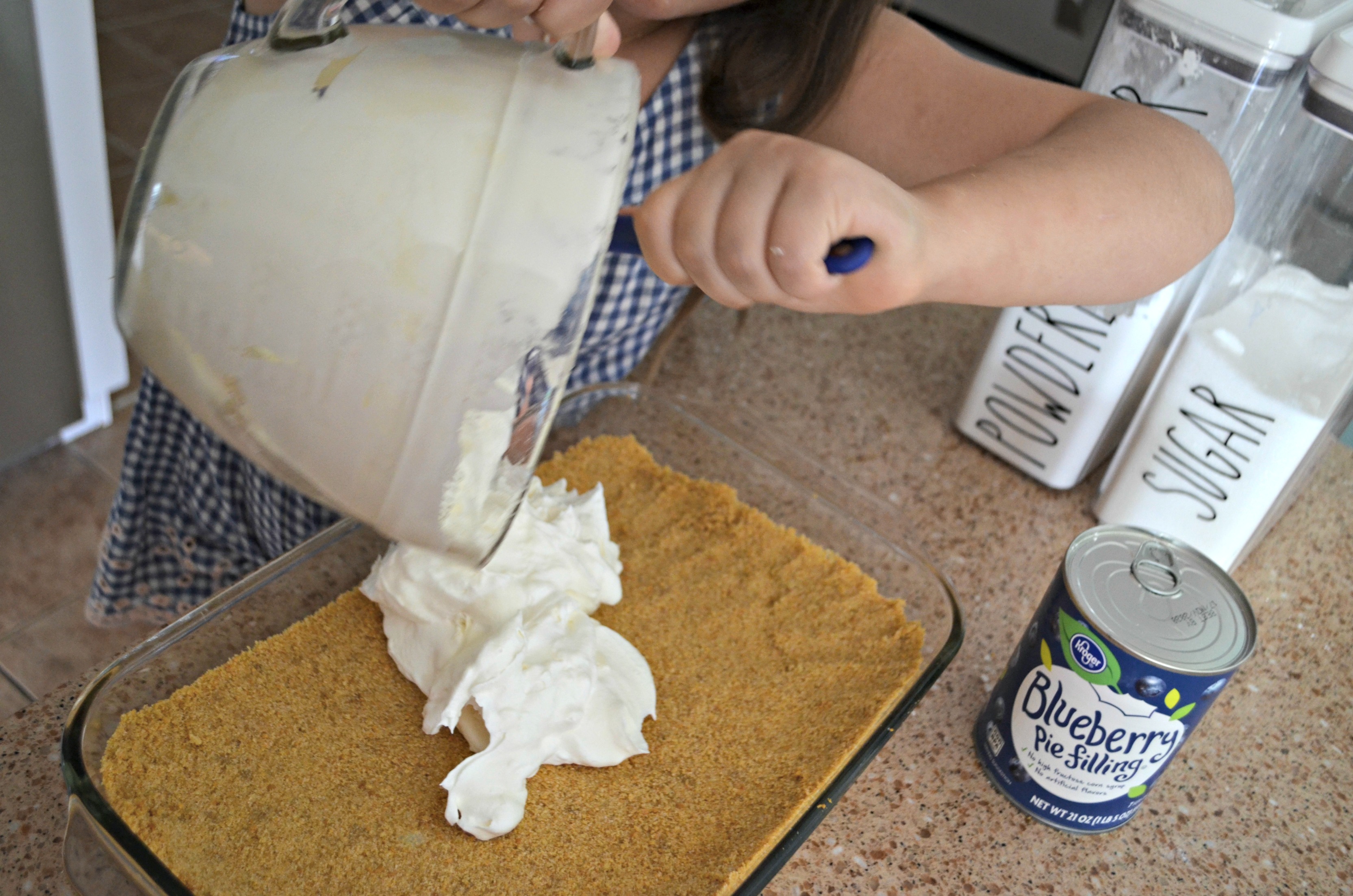 adding batter from a glass measuring cup into a crumb crust