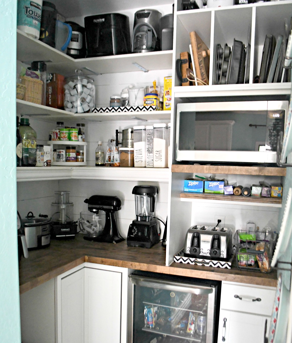 inside view of the pantry remodel with built in appliances, pantry goods, and pans