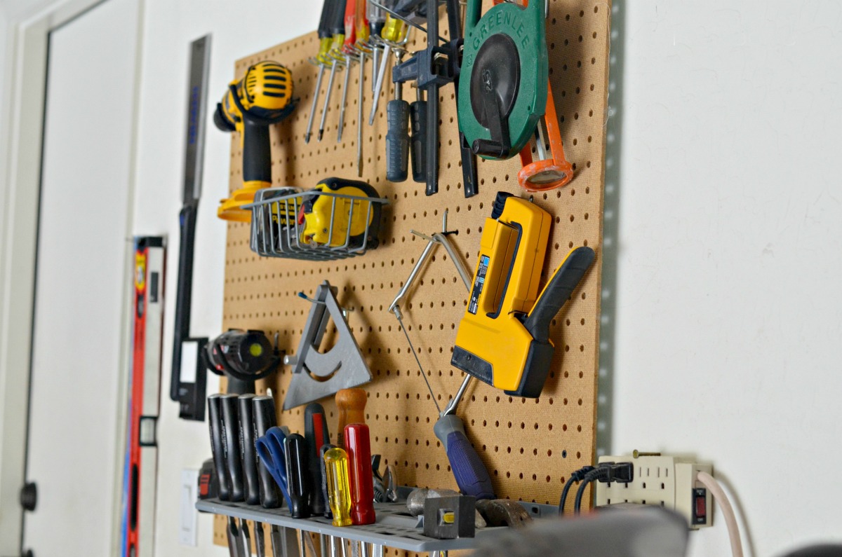 a pegboard wall being used for garage tool organization