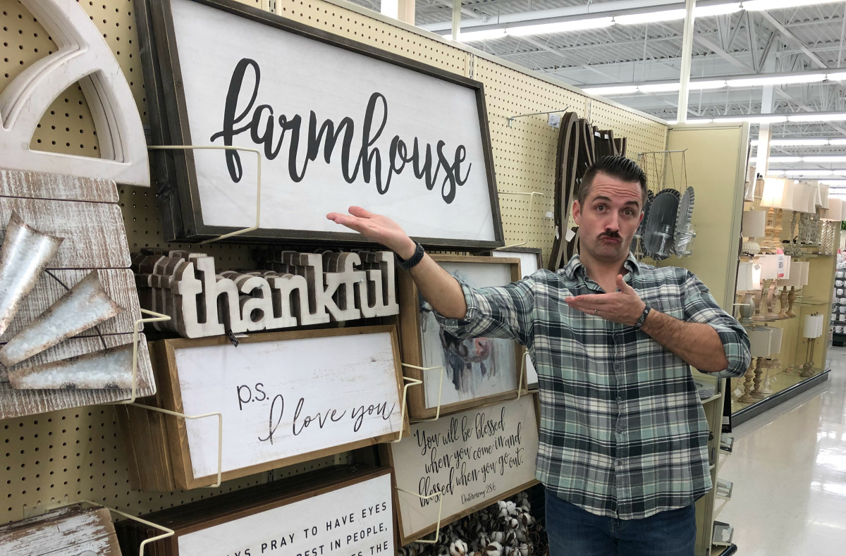 Sara's husband posing with farmhouse decor at Hobby Lobby