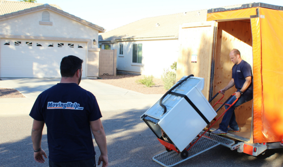 Moving company loading a washing machine onto a truck