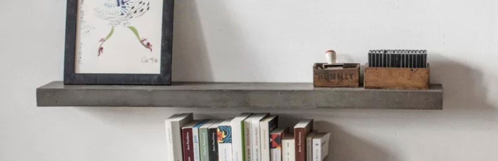 concrete shelf on wall with books and other accessories
