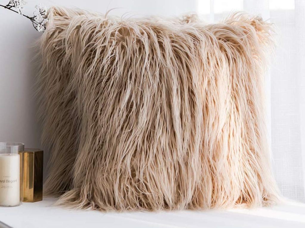 two tan beige brown faux fur throw pillows on bench