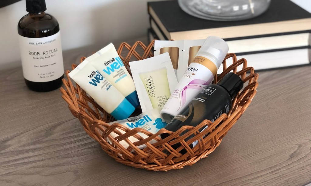 small basket with travel sized lotions shampoo conditioner soaps on top of dresser