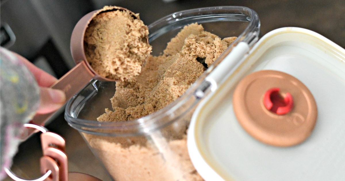 scooping brown sugar from a brown sugar keeper