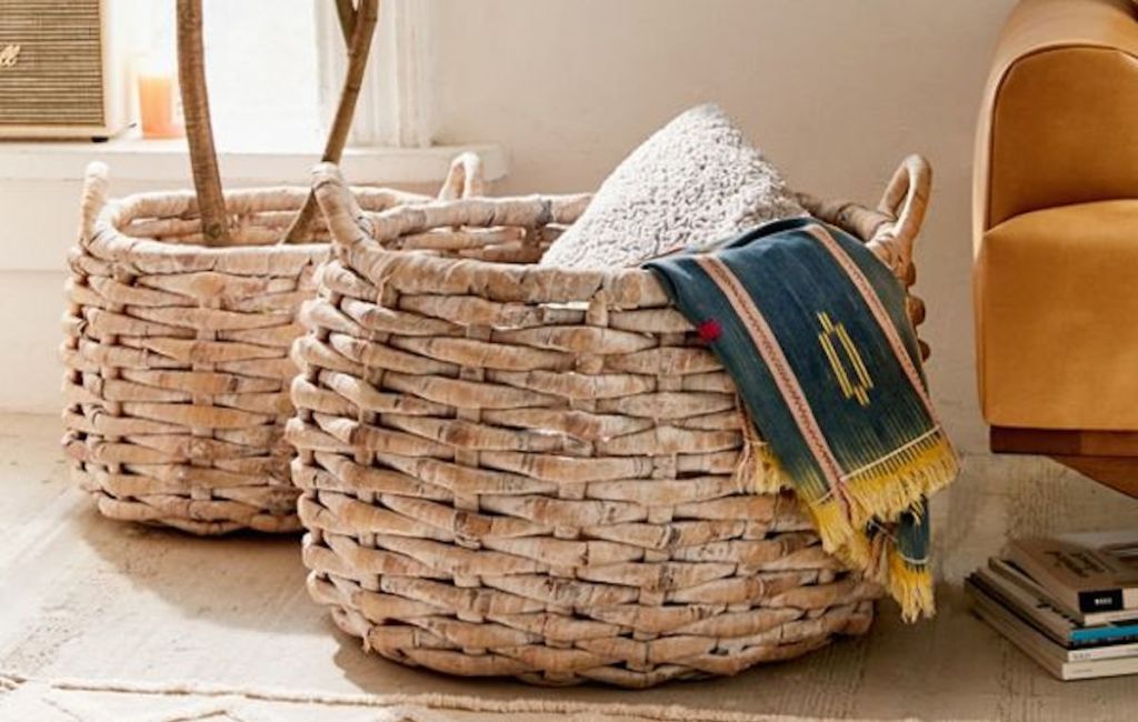 large knotted natural color baskets sitting on floor with plant and blankets