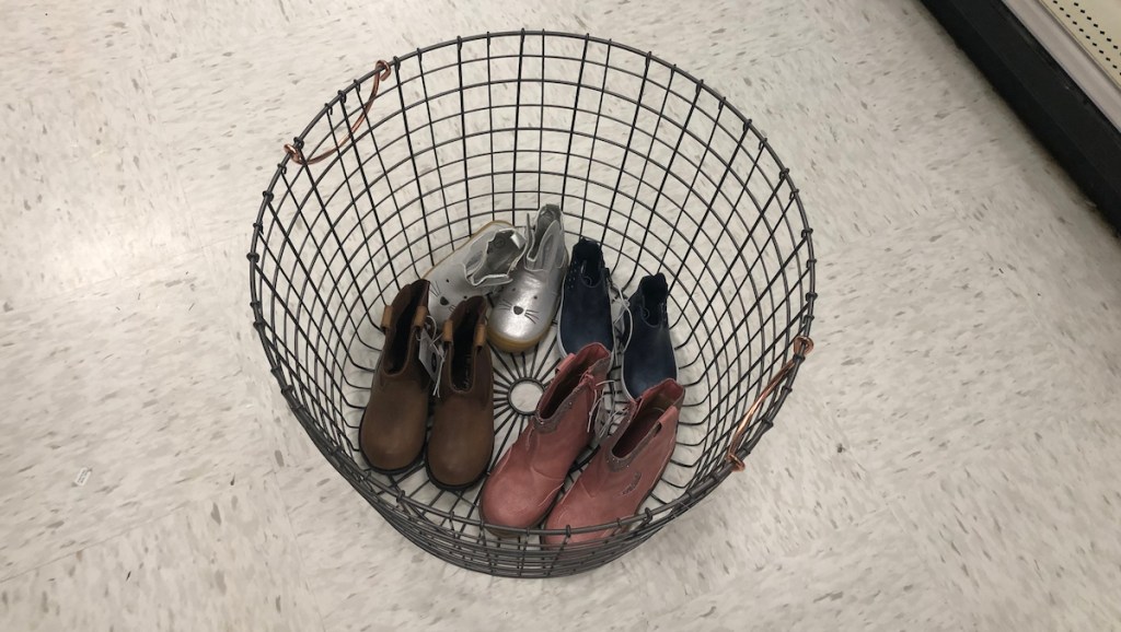 large wire basket bin with shoes copper handles four pairs of kids shoes 