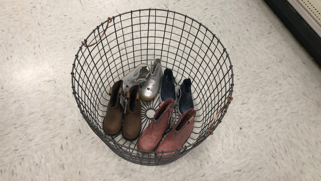 black wire basket sitting on floor with shoes inside