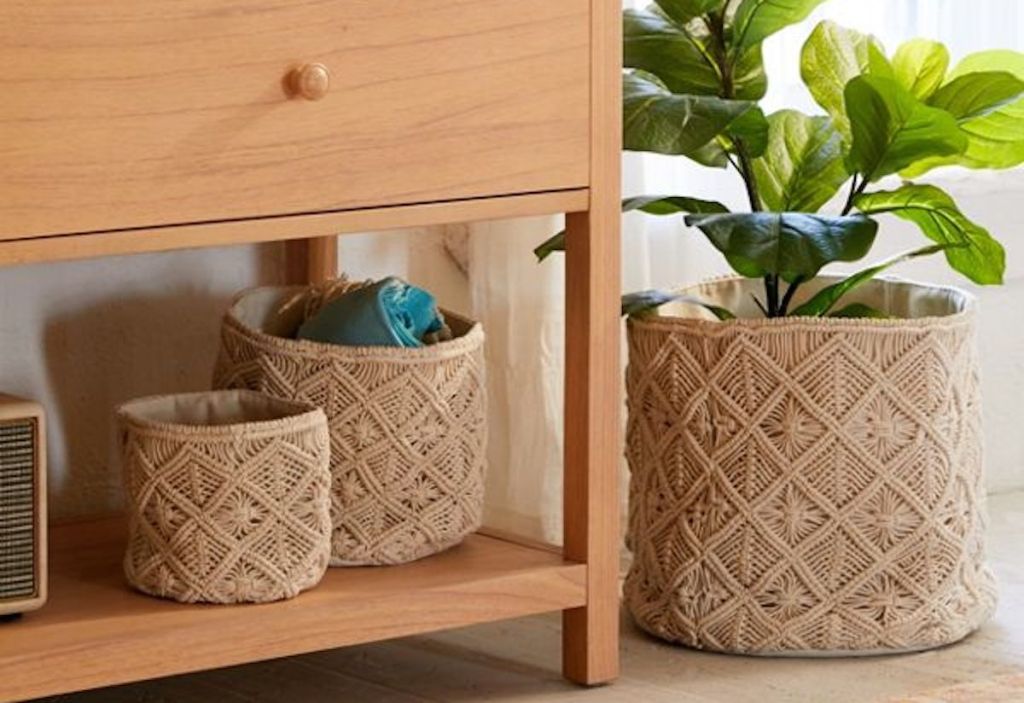 three macrame knotted baskets sitting on floor and console table with plant