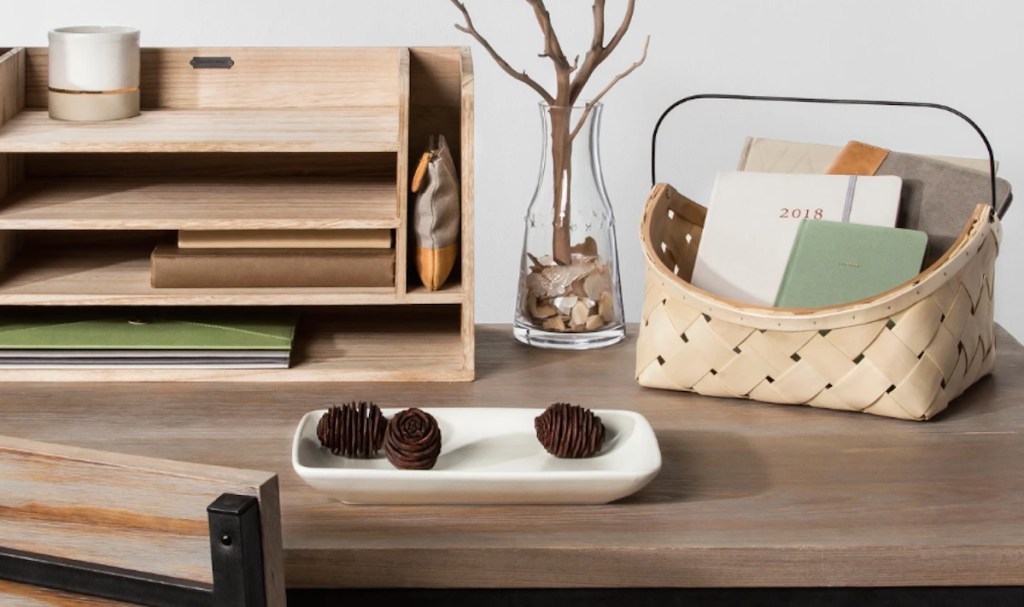 basketweave basket with iron handle sitting on desk with other office accessories