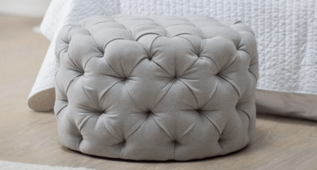allover tufted gray ottoman sitting on the floor
