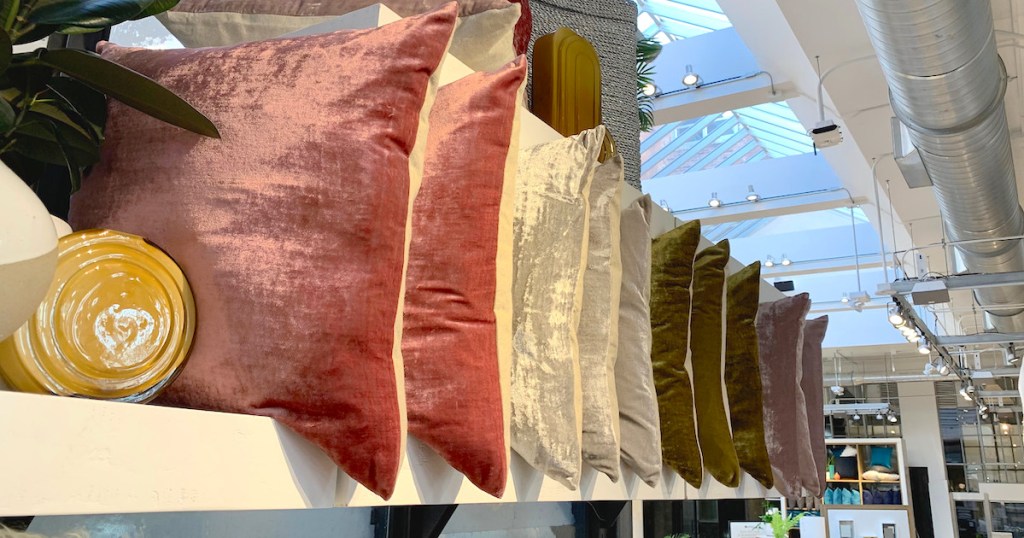 row of pink gray green velvet pillows on a shelf