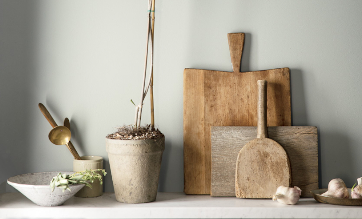 different sized cutting boards against a gray wall with planters