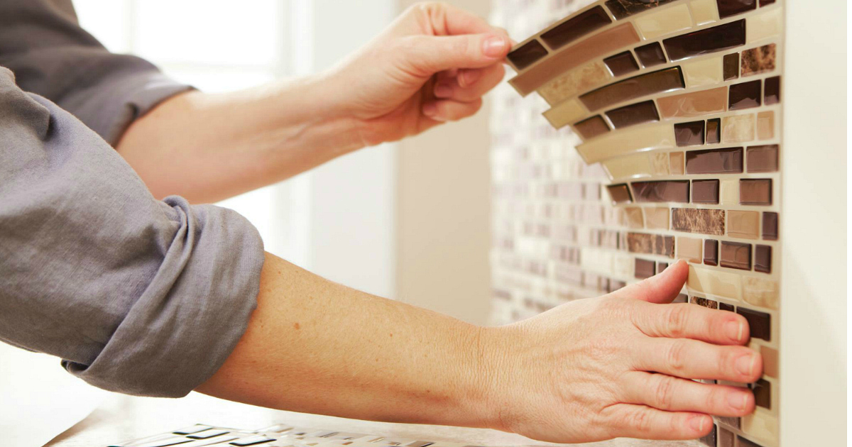 putting on peel and stick backsplash tiles in the kitchen