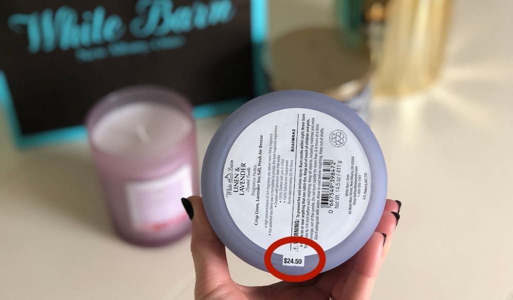 hand holding a purple candle with price circled in red