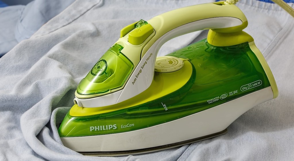 green iron steaming a light blue fabric