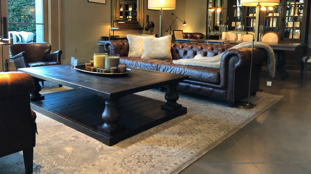 living room with large rug dark leather furniture couches and wood coffee table