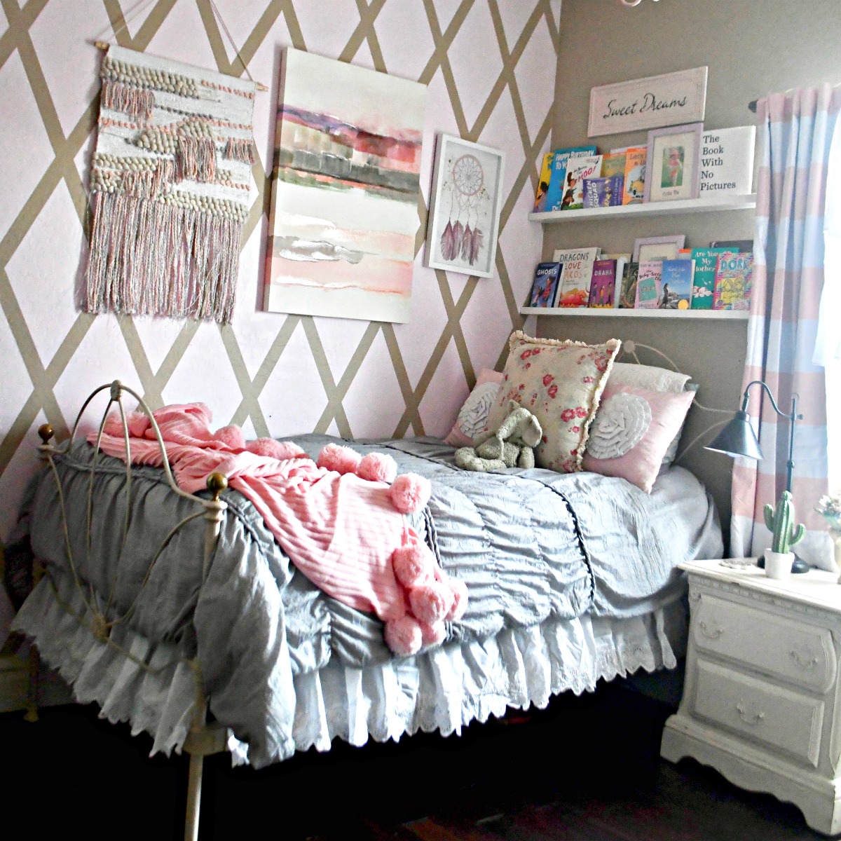 boho room with various decor and gray bedding with pink throw blanket