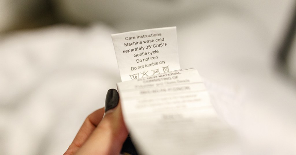 hand holding washing instructions on white tag