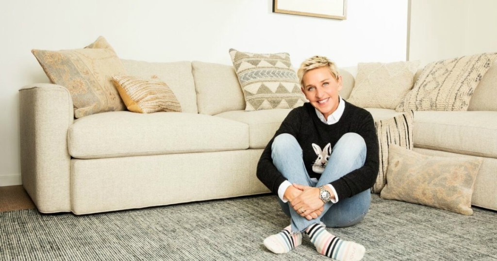 ellen degeneres smiling sitting on striped rug in living room 