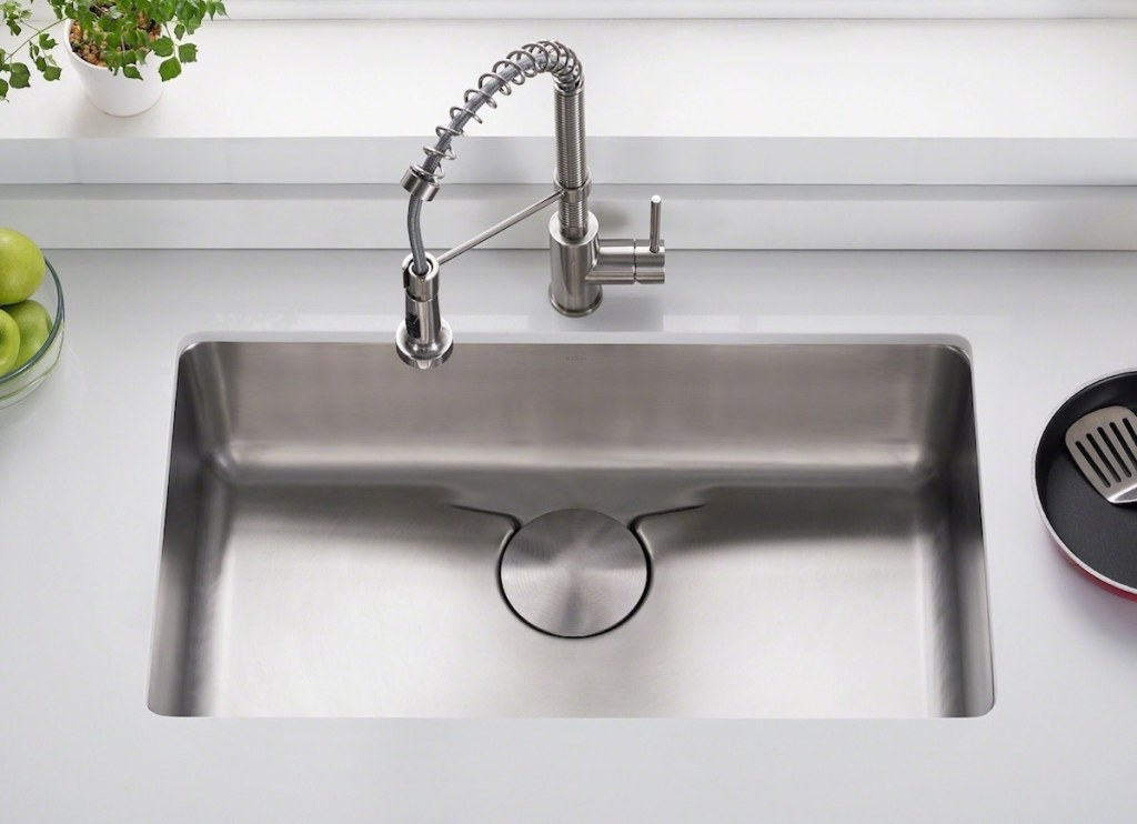 stainless steel sink with chrome faucet and white countertops