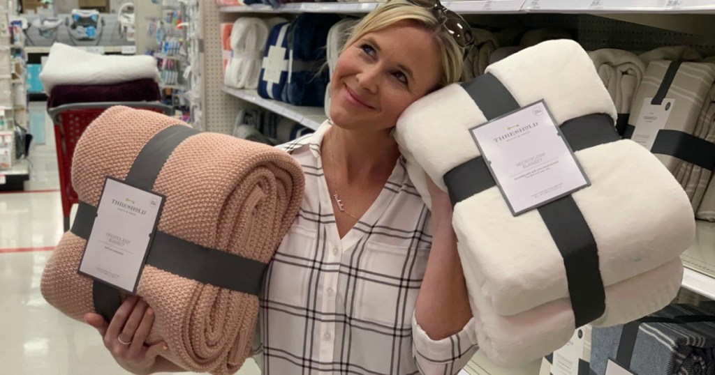 Collin holding Threshold blankets at Target