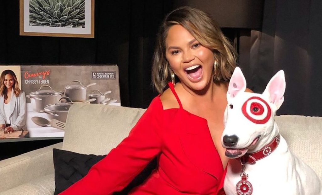 Chrissy Teigan with target red dog in dark room