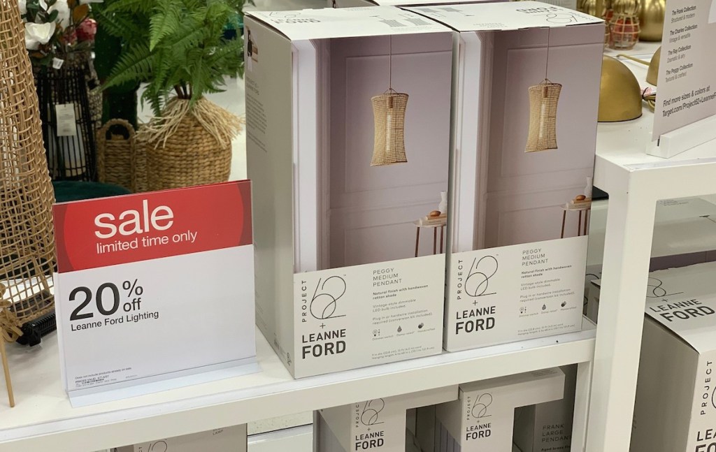 two boxes in store of woven natural colored pendant lights next to sale sign