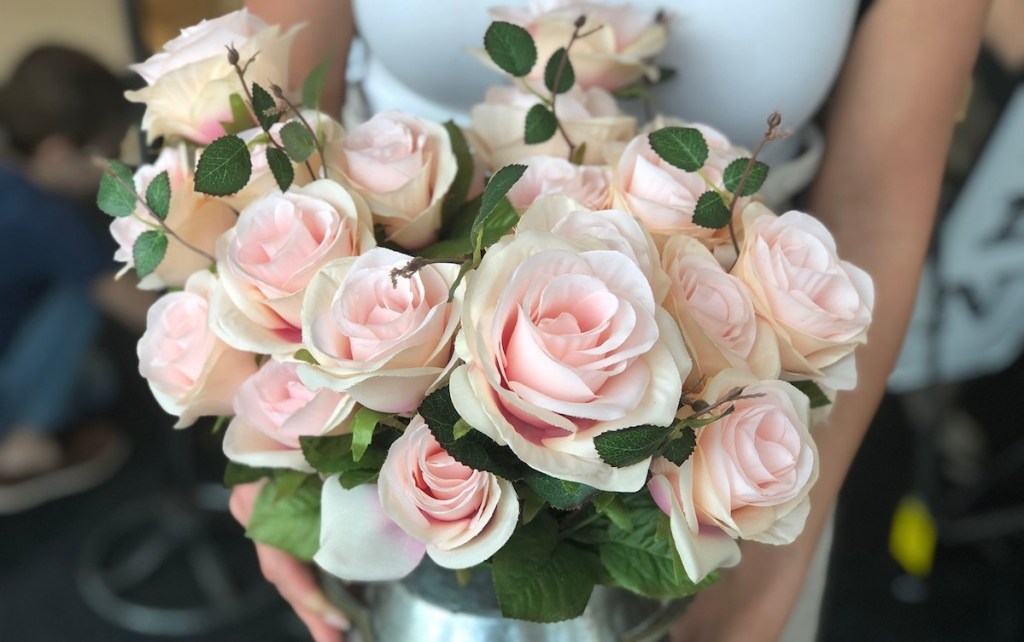 tons of pink roses in a metal jar