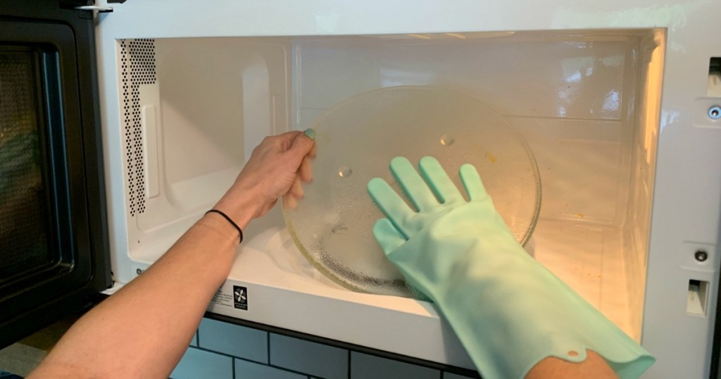 Cleaning microwave with kitchen glove 