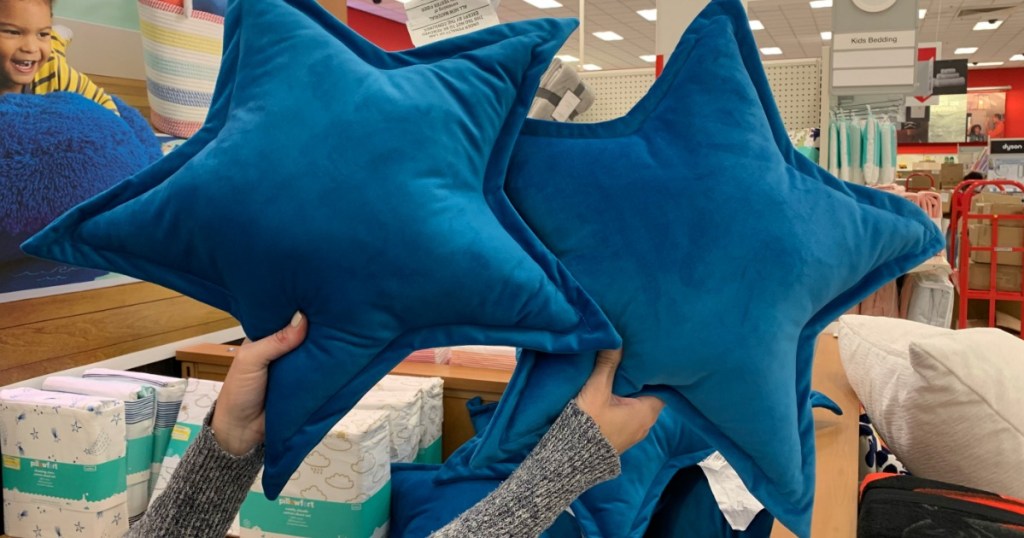 holding Pillowfort star throw pillows 