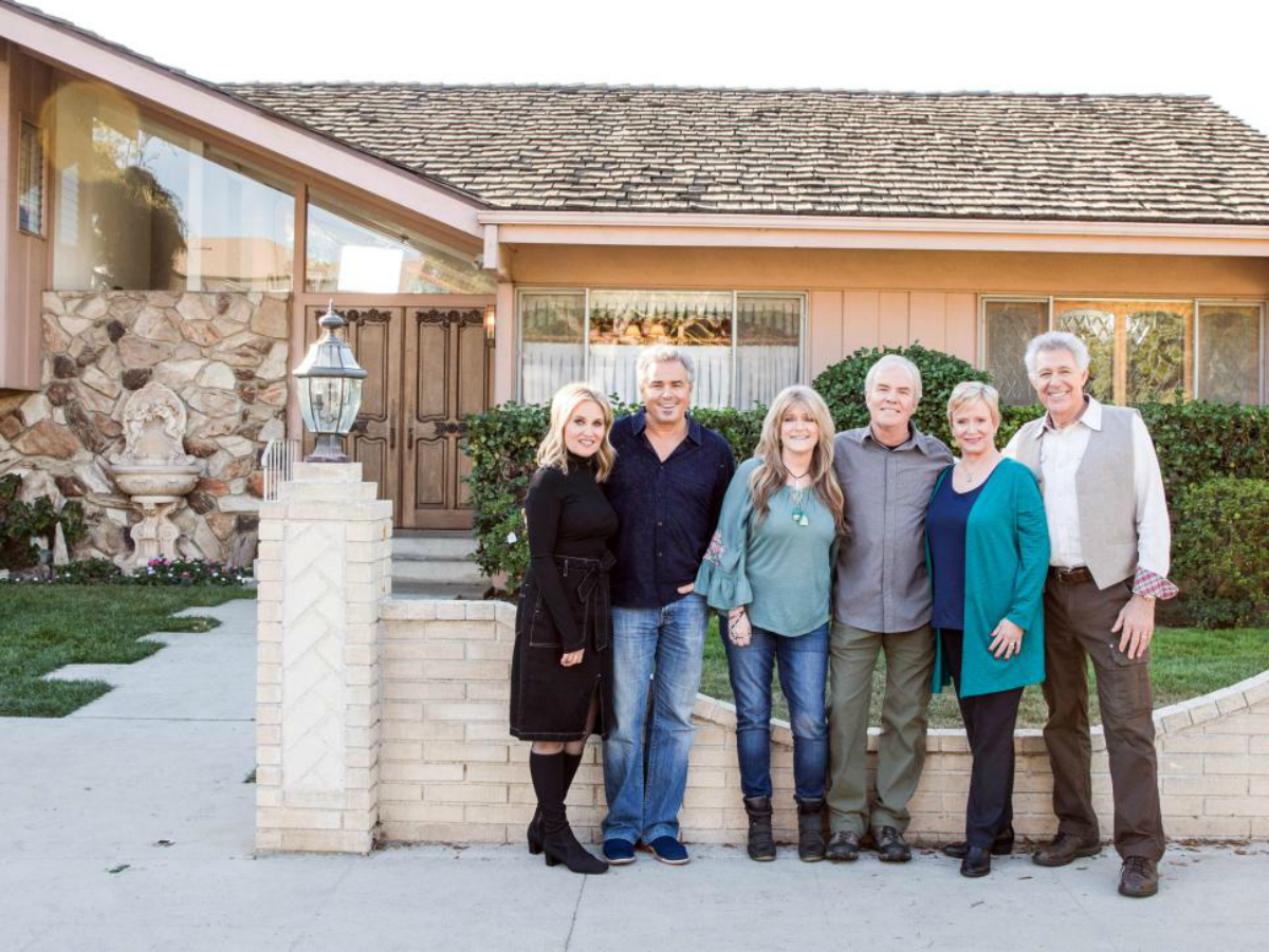 The Original Brady Bunch Crew standing outside of the house