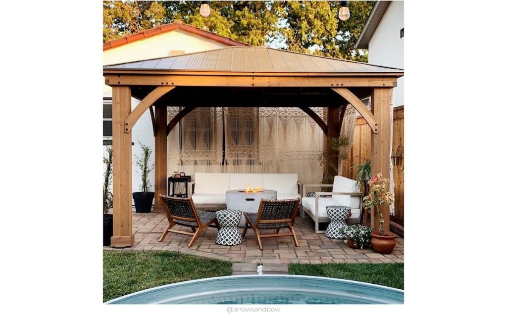gorgeous cozy outdoor space with furniture and cement firepit and accent chairs 