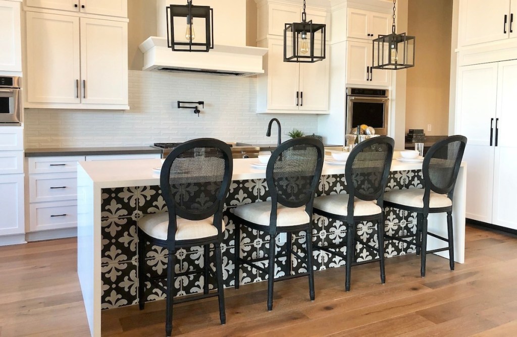 white kitchen cabinets with bold black round rattan barstools 