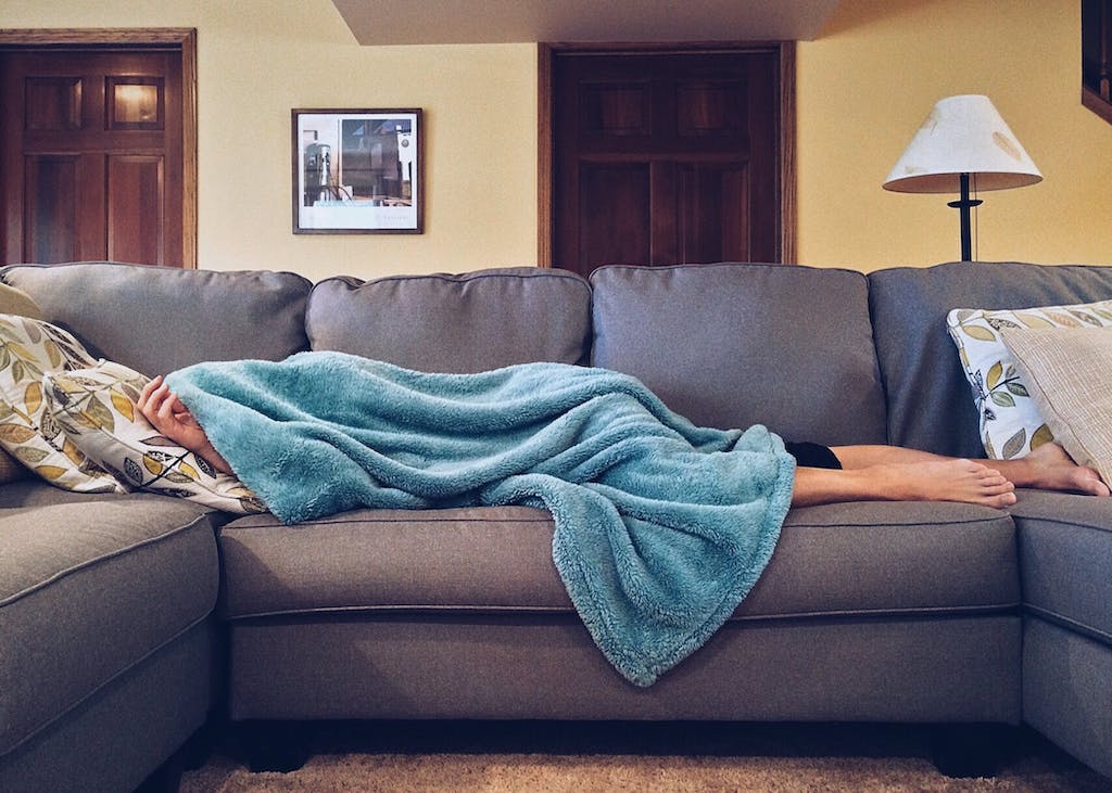 woman napping on the couch with a blanket 