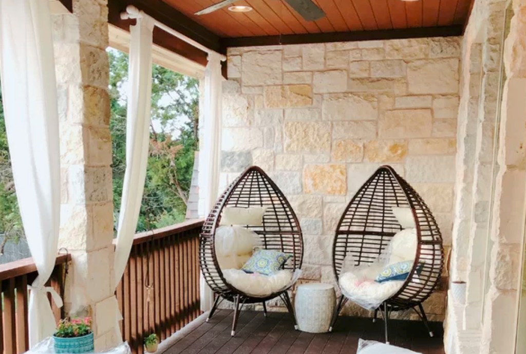 two black egg chairs sitting on porch 