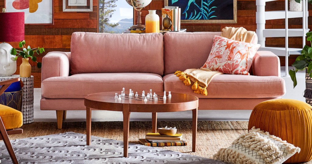 pink velvet sofa couch in eclectic styled living room with chess coffee table and other bold colored decor