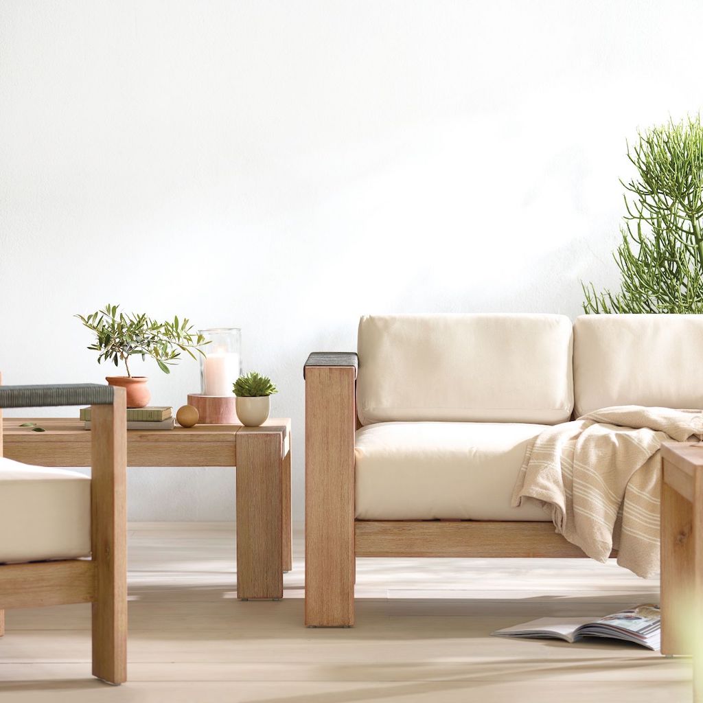 wood patio set with white cushions and plants 