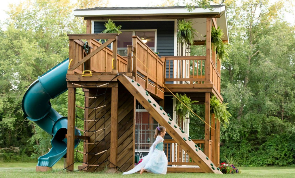 girl running through yard near playhouse