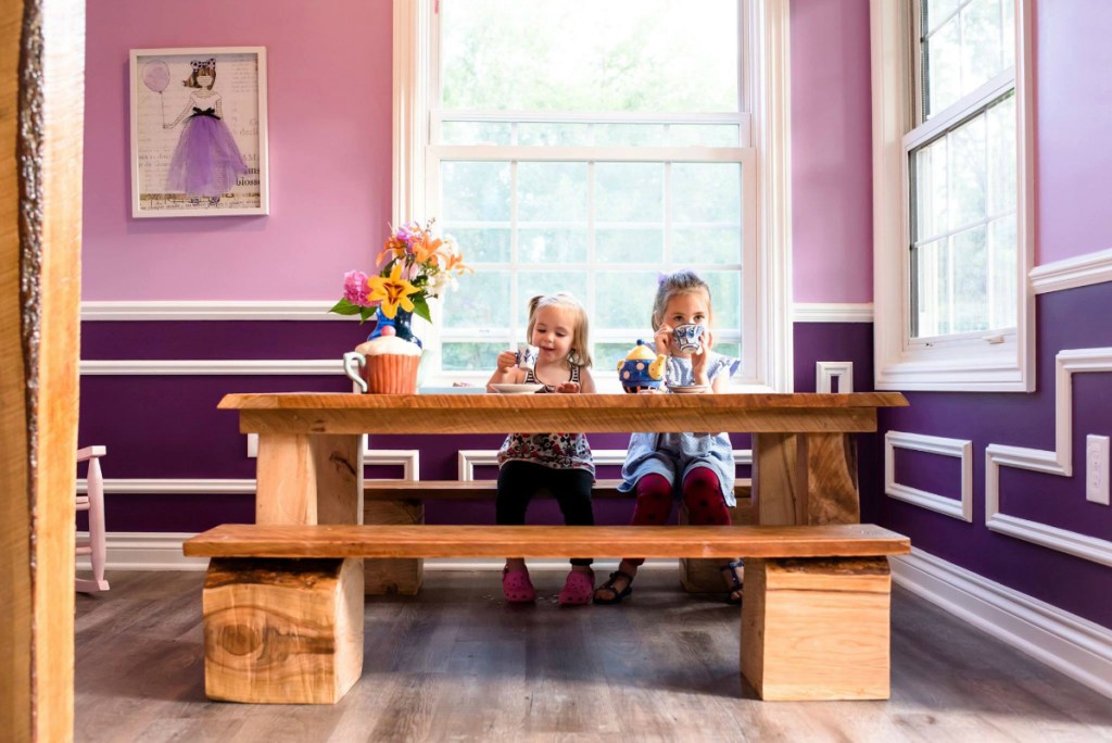 girls sitting at table having tea party