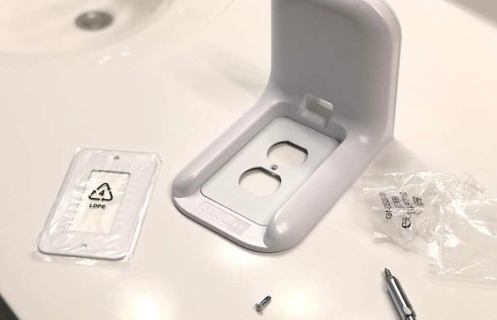 white outlet shelf sitting on white counter with screws