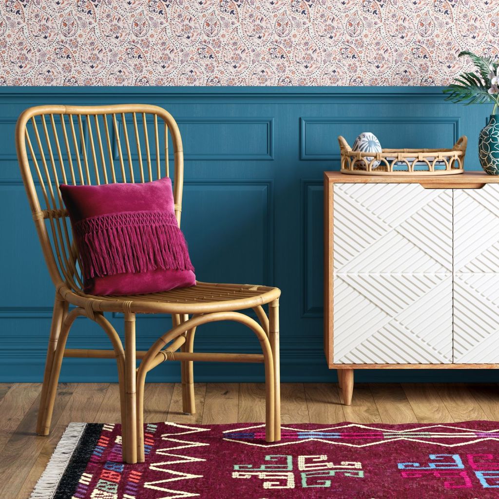 rattan chair with pink pillow and colorful carpet 