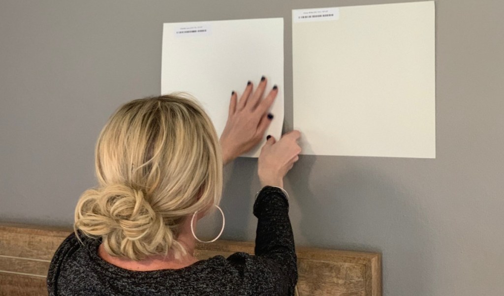 woman with blonde hair holding sticker paint samples