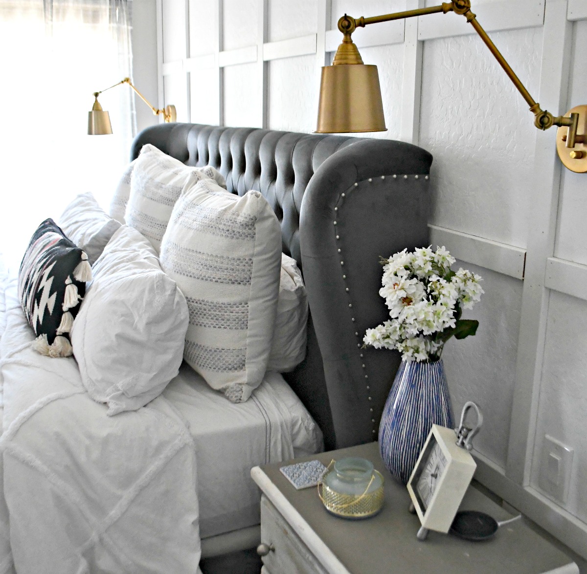 side view of TOV wingback bed and gold sconce lighting 