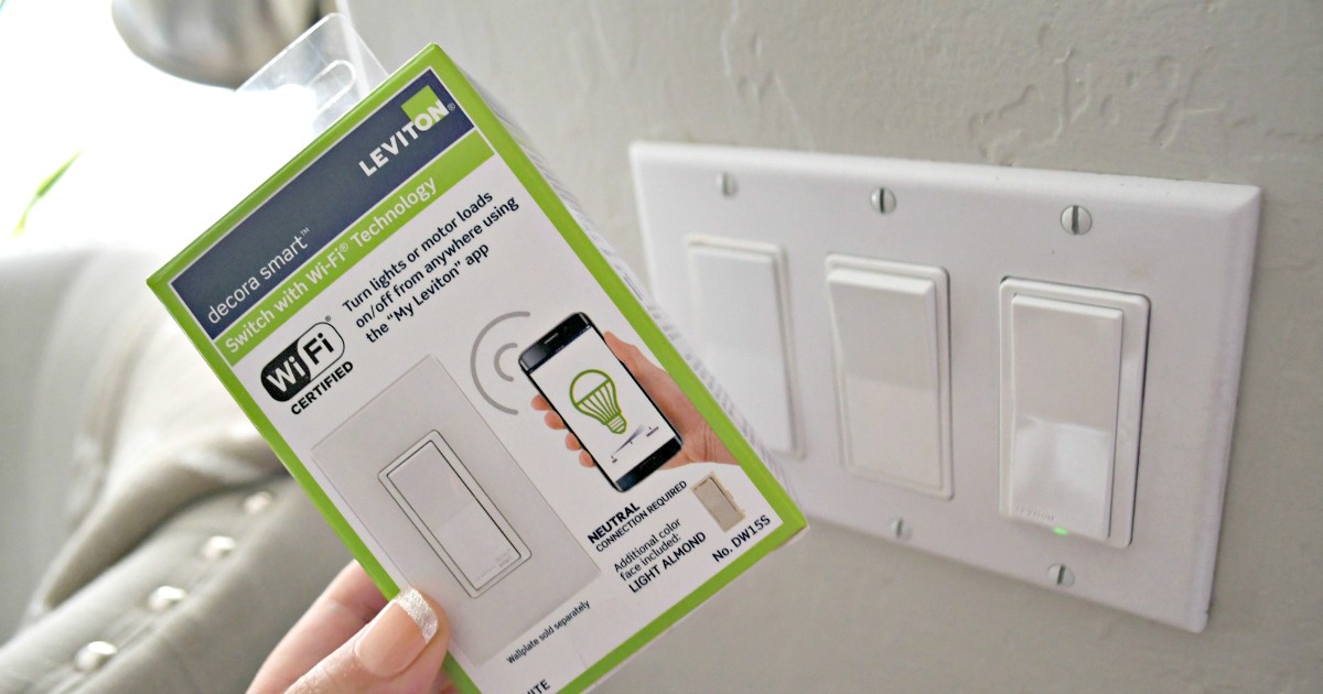 holding up a Leviton wifi light switch box next to switch