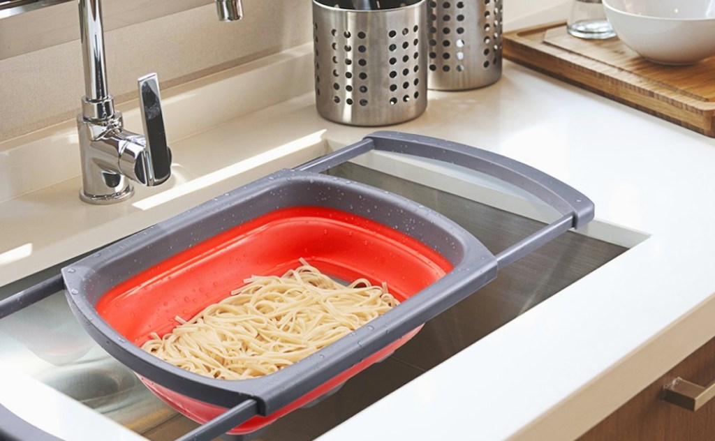 red colander in sink with pasta