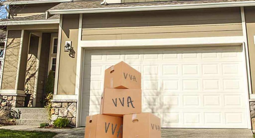 cardboard brown boxes on driveway in front of house