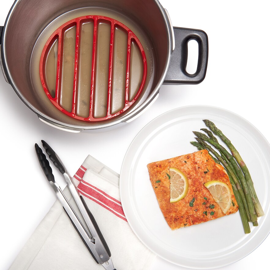 OXO pressure cooker rack in large pot next to plate with fish 