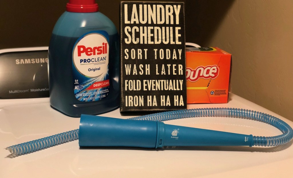 blue lint lizard on tip of dryer with laundry products